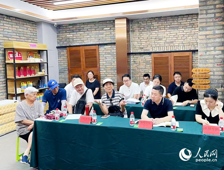 居民唐丽娟讲述小区物业治理前后的变化。人民网记者 刘宝琴摄